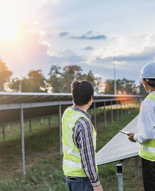 Architectural engineer working on solar panels and photovoltaic farms at a construction site, meeting, discussing, designing, planning, clean energy concept.